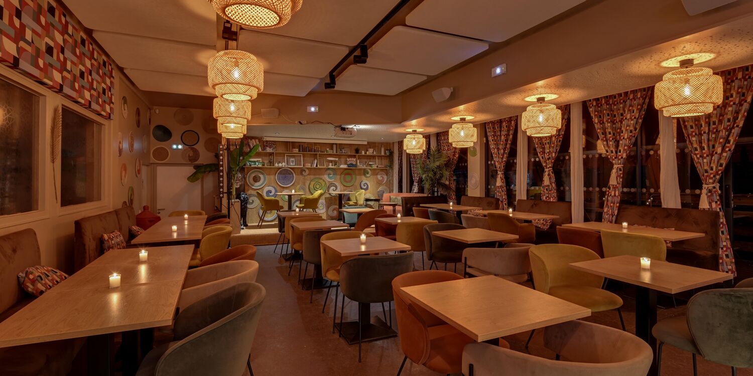 Salle du restaurant &Ocirc;18, avec tables, banquettes et luminaires suspendus