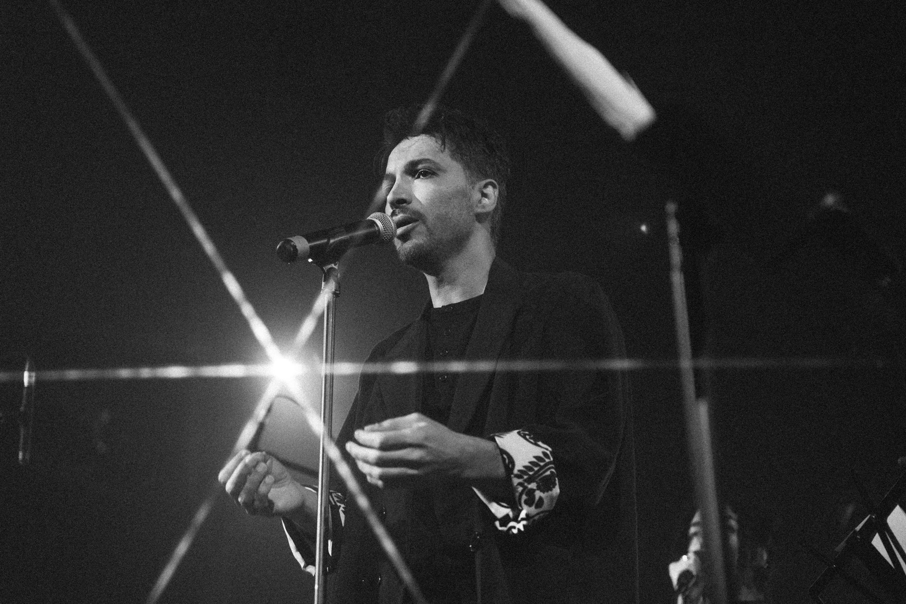 Dariush Azar au chant sur sc&egrave;ne, photographie en noir et blanc.